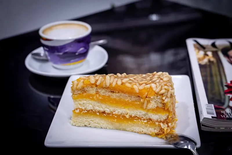 Fotografía gastronómica: porción de tarta de hojaldre y crema junto a un café