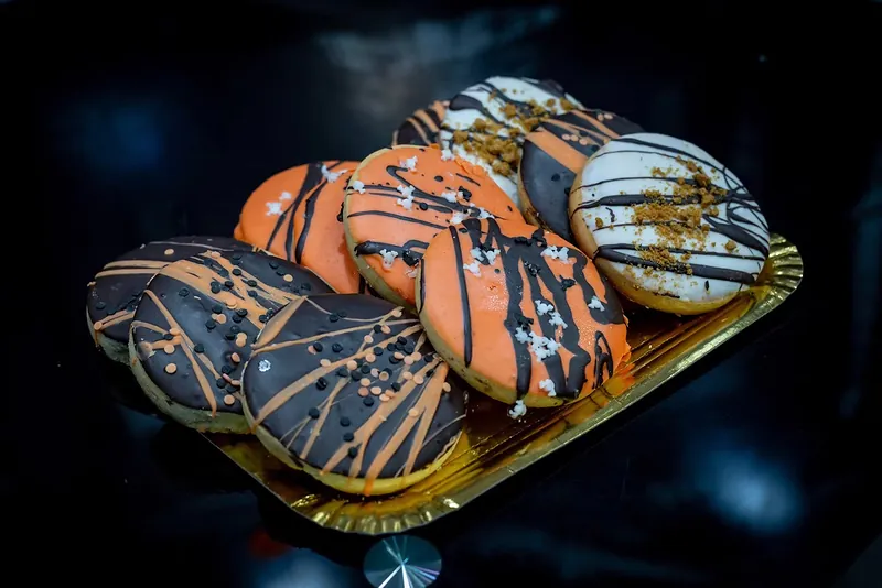 Bombones de chocolate decorados con hilos de colores sobre bandeja dorada