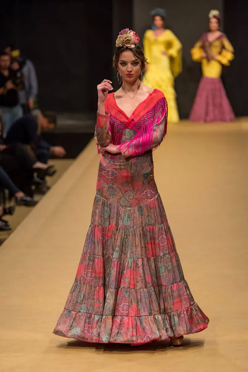 Traje de flamenca estampado en tonos rosas desfilando por la pasarela