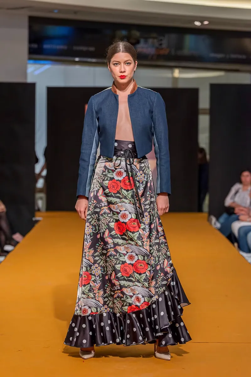 Modelo con falda estampada de volantes y cazadora vaquera en pasarela