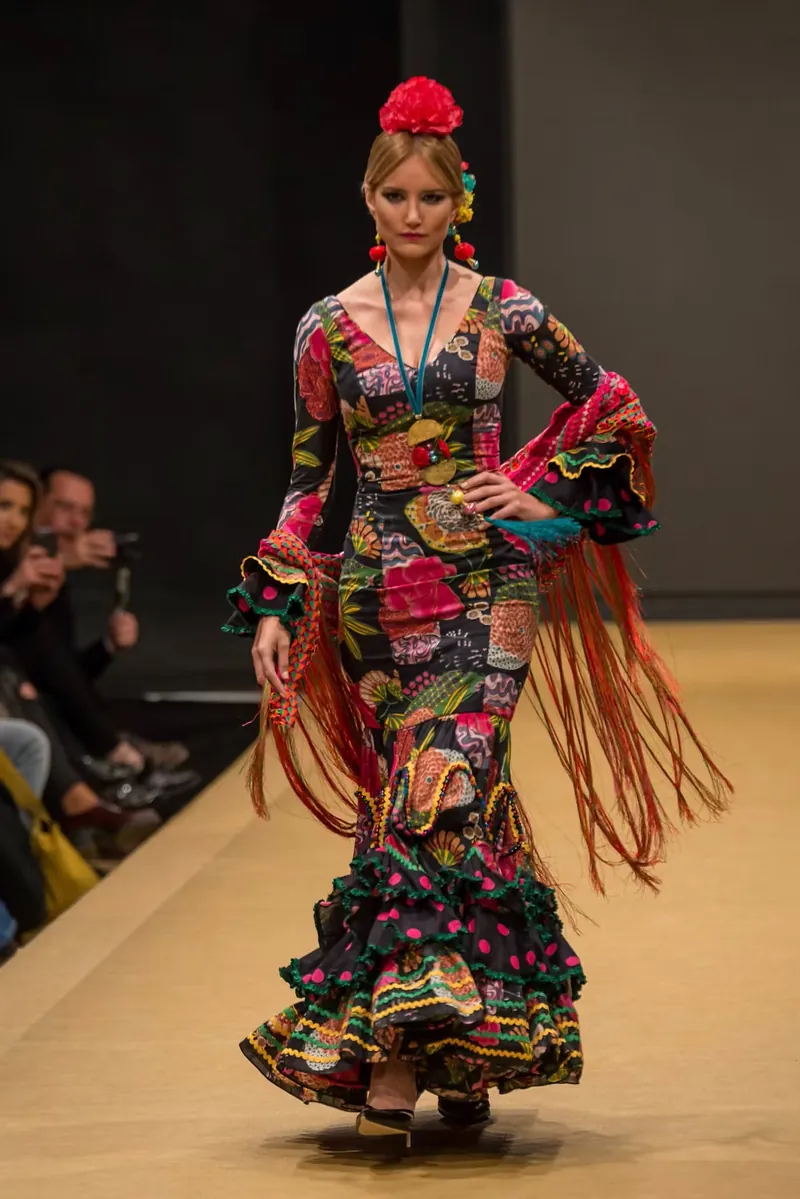 Traje de flamenca multicolor de volantes recorriendo la pasarela