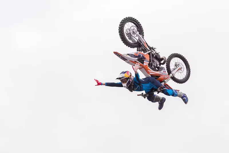 Piloto de motocross freestyle suspendido en el aire durante un salto